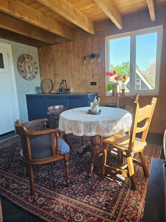 Eethoek met ronde tafel, kanten kleed en de keuken op de achtergrond