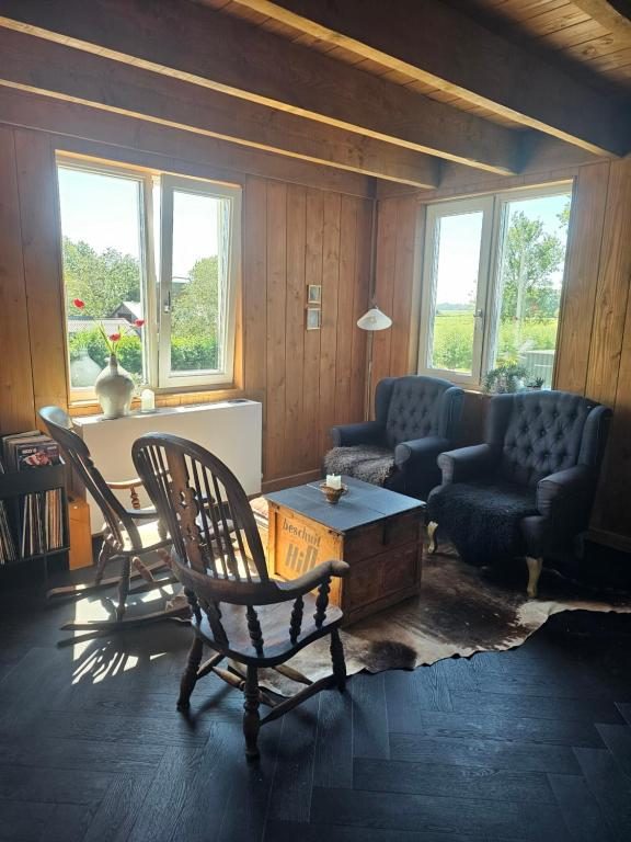 Zithoek met fauteuils, schommelstoel en houten wanden in het appartement